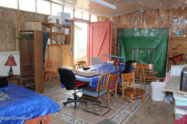 bedroom featuring wood finished floors and wooden walls