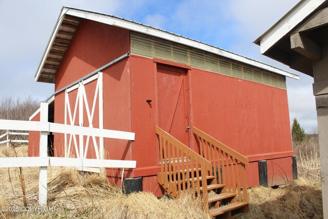 view of outdoor structure featuring fence and an outdoor structure
