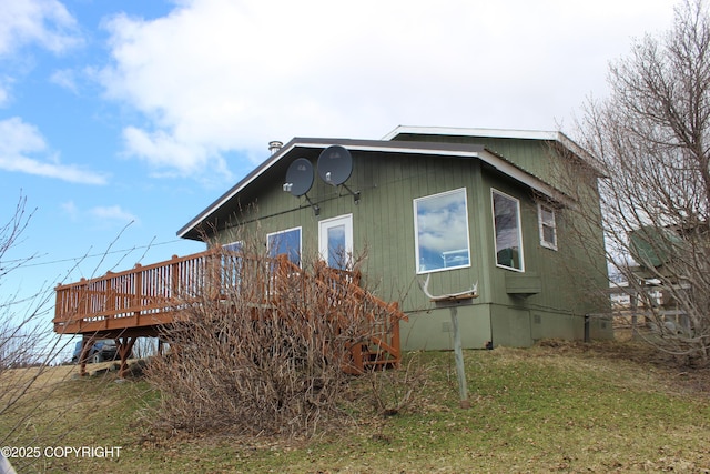 view of side of property with a yard and a deck