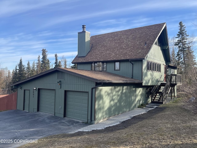 view of property exterior featuring roof with shingles, fence, stairs, and a chimney