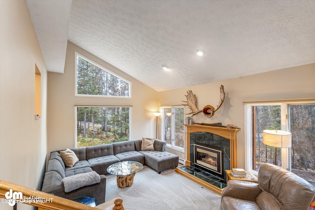 carpeted living area featuring a textured ceiling, high vaulted ceiling, and a fireplace