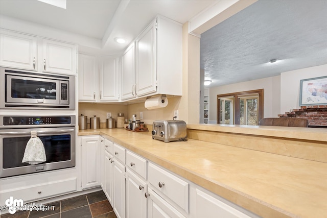 kitchen with light countertops, white cabinets, and stainless steel appliances