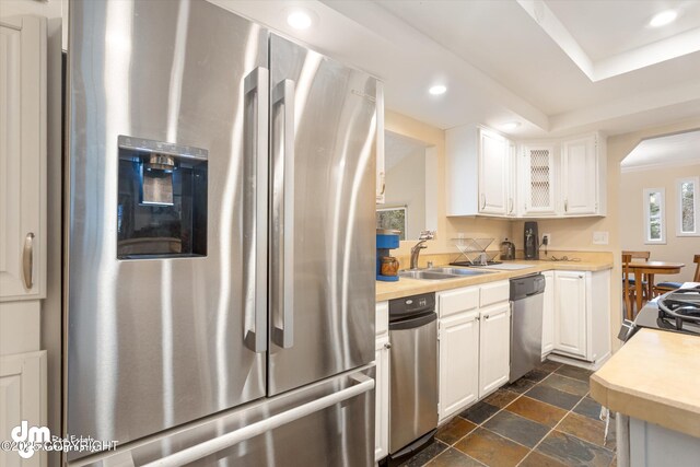 kitchen with light countertops, a sink, white cabinetry, and stainless steel appliances