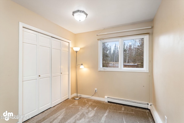 unfurnished bedroom with carpet floors, baseboards, baseboard heating, and a closet