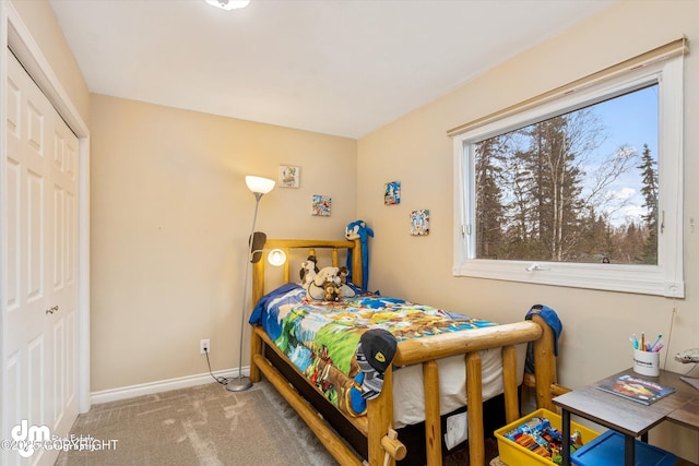 carpeted bedroom with baseboards and a closet