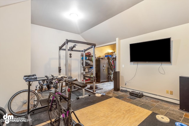 exercise area featuring vaulted ceiling, a baseboard heating unit, and stone finish flooring