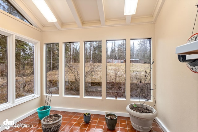 sunroom / solarium featuring tile patterned floors, baseboards, and lofted ceiling