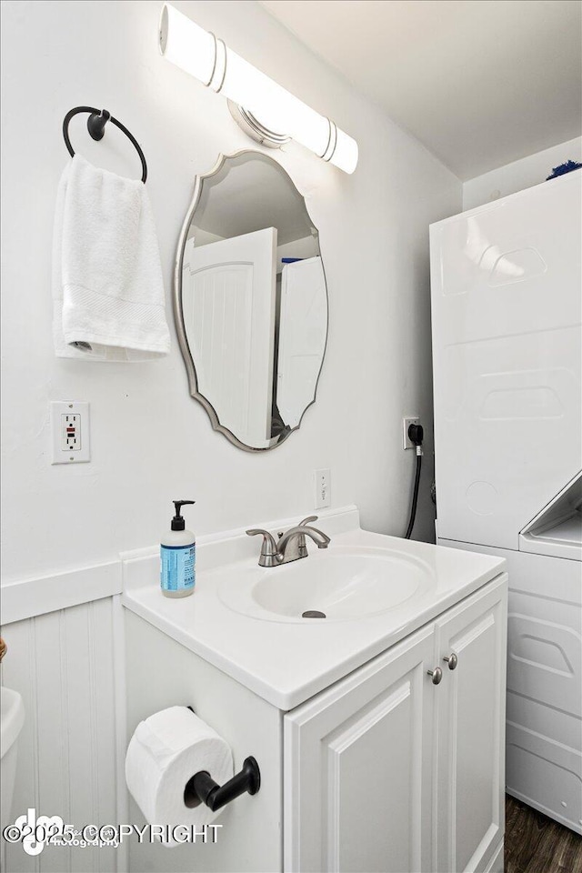 bathroom with vanity, a wainscoted wall, and wood finished floors