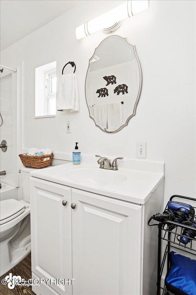 bathroom with toilet, shower / tub combination, wood finished floors, and vanity