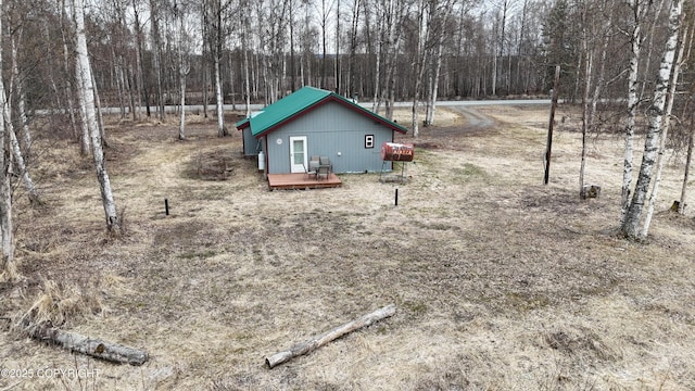 view of yard with a wooden deck and a wooded view