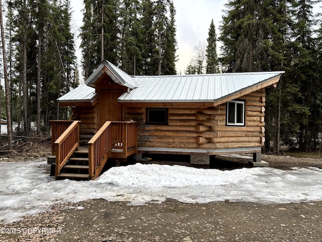log-style house with log exterior and metal roof
