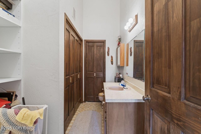 23675 Glacier View Dr, Eagle River, AK 99577 - bathroom with vanity, a textured wall, toilet, and visible vents