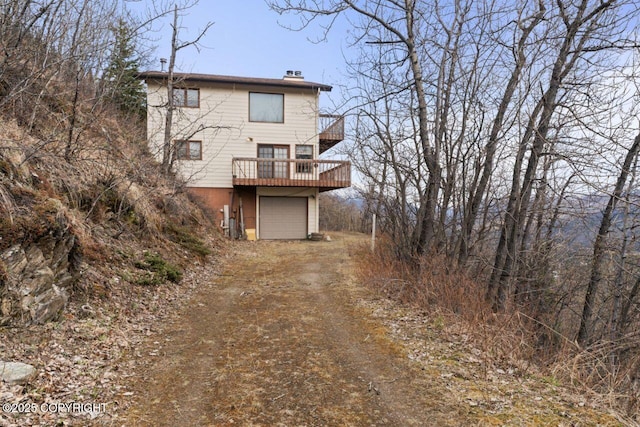 23675 Glacier View Dr, Eagle River, AK 99577 - rear view of house with a wooden deck, driveway, a chimney, and a garage