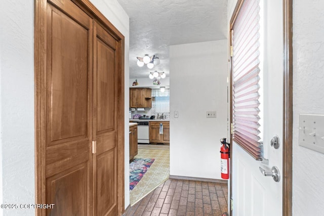 23675 Glacier View Dr, Eagle River, AK 99577 - hall featuring a textured ceiling, baseboards, and brick floor