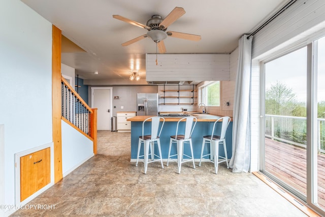 430 Washington St, Ketchikan, AK 99901 - kitchen featuring ceiling fan, a breakfast bar area, stainless steel refrigerator with ice dispenser, a peninsula, and butcher block counters