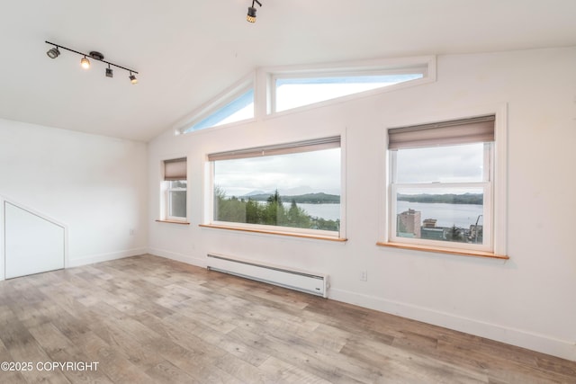 430 Washington St, Ketchikan, AK 99901 - spare room with baseboards, lofted ceiling, a baseboard heating unit, and wood finished floors
