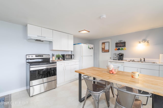 430 Washington St, Ketchikan, AK 99901 - kitchen with a kitchen bar, under cabinet range hood, white cabinets, a sink, and appliances with stainless steel finishes