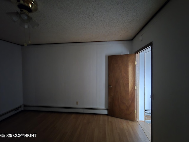 empty room featuring a baseboard heating unit, a textured ceiling, ceiling fan, and wood finished floors