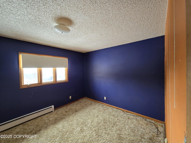 carpeted spare room with a textured ceiling, a baseboard heating unit, and baseboards