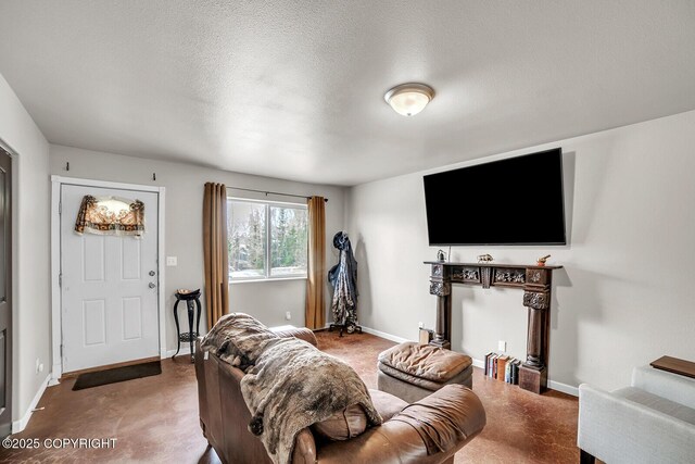 living area with a textured ceiling and baseboards