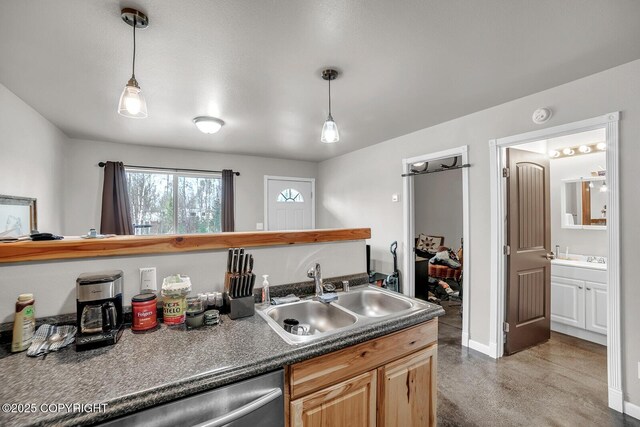 kitchen featuring stainless steel dishwasher, dark countertops, baseboards, a sink, and hanging light fixtures
