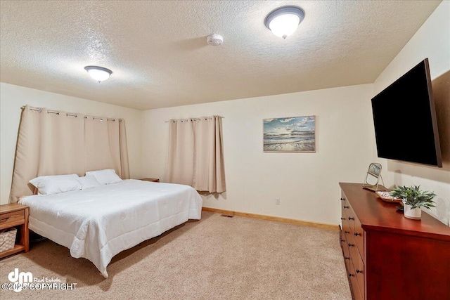 bedroom featuring light colored carpet, a textured ceiling, baseboards, and visible vents