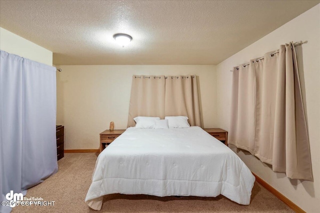bedroom with light colored carpet, a textured ceiling, and baseboards