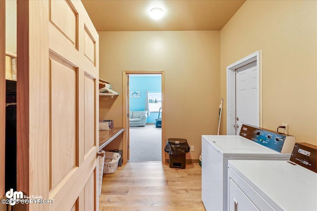 laundry area with laundry area, light wood-type flooring, and washing machine and dryer