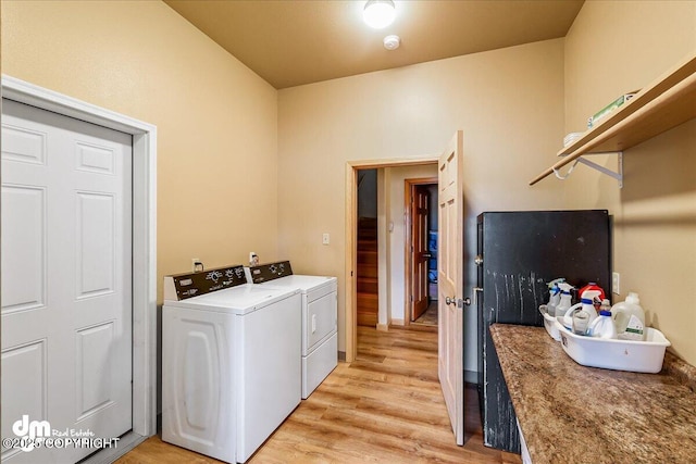 washroom with light wood finished floors, independent washer and dryer, and laundry area