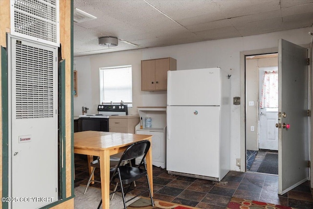 869 Bouton Ct, Fairbanks, AK 99712 - kitchen with freestanding refrigerator, a heating unit, electric stove, washer and dryer, and dark stone finish flooring