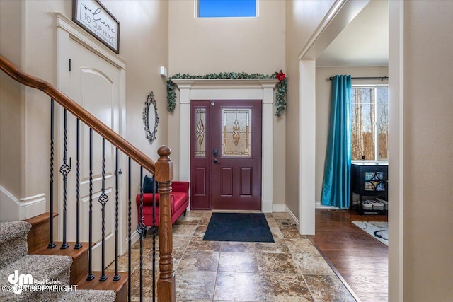 7865 S Settlers Bay Dr, Wasilla, AK 99623 - entrance foyer featuring stairs, baseboards, stone finish floor, and a towering ceiling