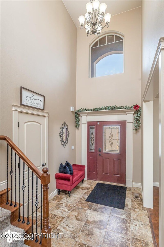 7865 S Settlers Bay Dr, Wasilla, AK 99623 - entrance foyer with a high ceiling, a chandelier, baseboards, stone finish flooring, and stairway