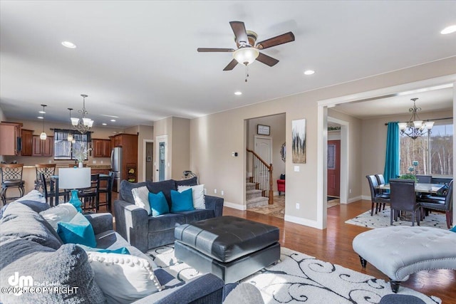 7865 S Settlers Bay Dr, Wasilla, AK 99623 - living room featuring ceiling fan with notable chandelier, recessed lighting, baseboards, wood finished floors, and stairway