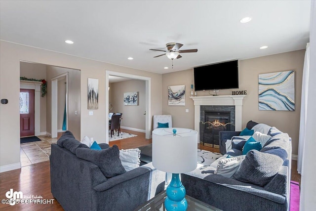 7865 S Settlers Bay Dr, Wasilla, AK 99623 - living area with a glass covered fireplace, wood finished floors, baseboards, ceiling fan, and recessed lighting
