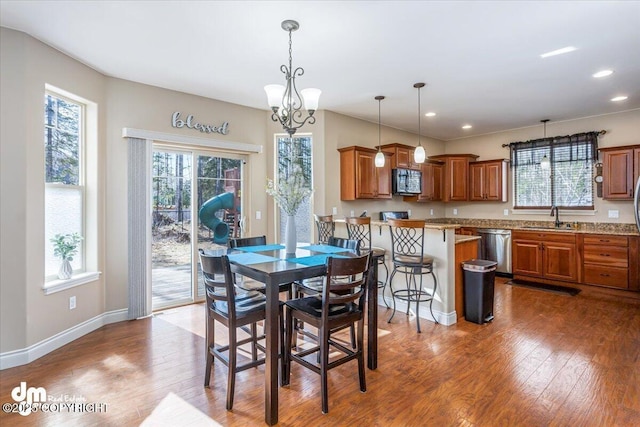 7865 S Settlers Bay Dr, Wasilla, AK 99623 - dining room with a chandelier, a healthy amount of sunlight, and wood finished floors