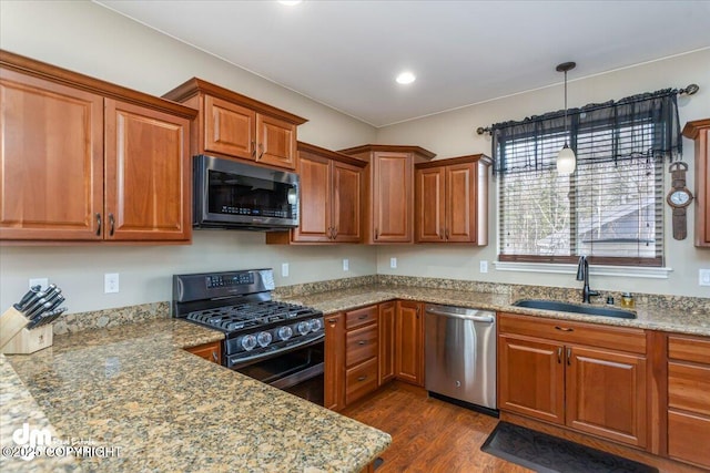 7865 S Settlers Bay Dr, Wasilla, AK 99623 - kitchen featuring brown cabinetry, a sink, dark wood finished floors, and stainless steel appliances