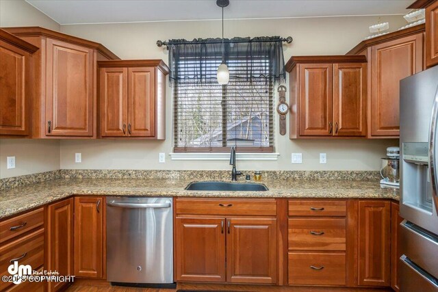 7865 S Settlers Bay Dr, Wasilla, AK 99623 - kitchen featuring stainless steel appliances, brown cabinetry, and a sink