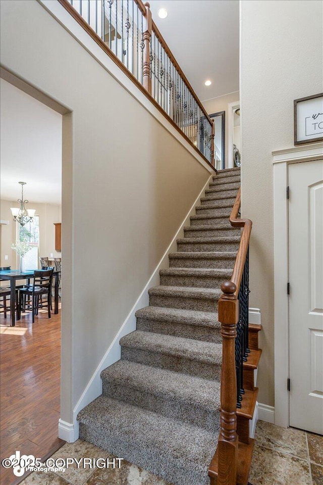 7865 S Settlers Bay Dr, Wasilla, AK 99623 - staircase with recessed lighting, baseboards, a notable chandelier, and wood finished floors