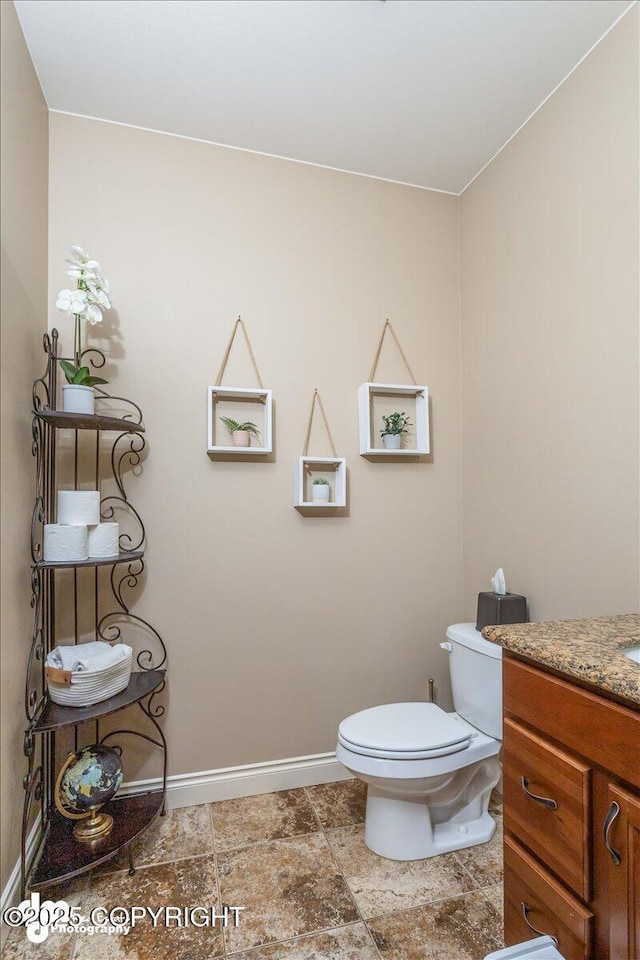 7865 S Settlers Bay Dr, Wasilla, AK 99623 - bathroom featuring baseboards, vanity, and toilet
