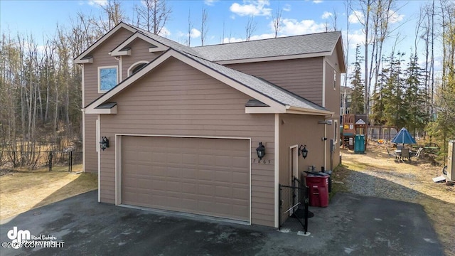 7865 S Settlers Bay Dr, Wasilla, AK 99623 - view of home's exterior with roof with shingles, fence, driveway, and a garage