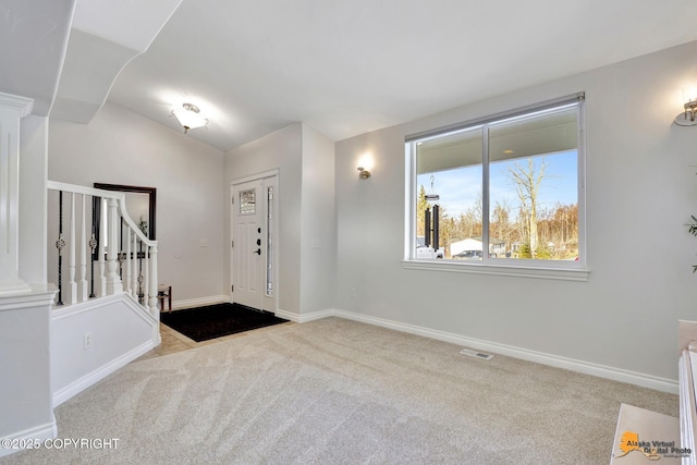 foyer featuring stairs, carpet flooring, and baseboards