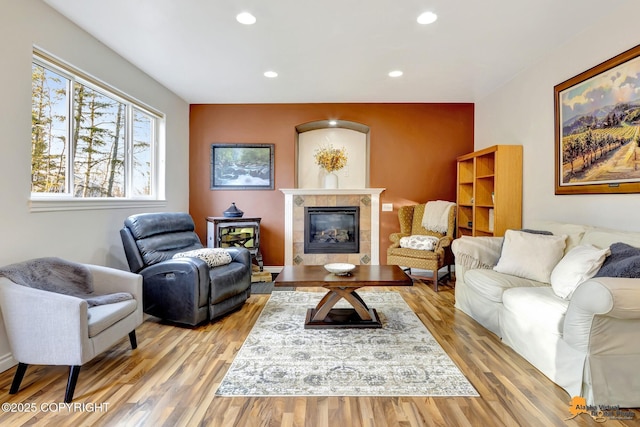 living area with recessed lighting, light wood finished floors, and a tile fireplace