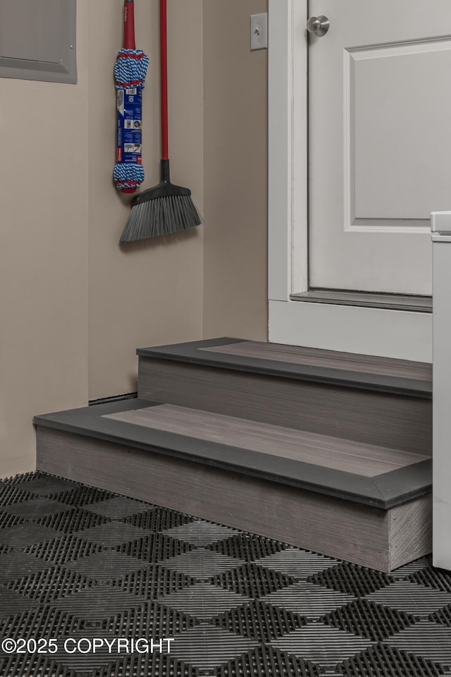 stairway featuring tile patterned flooring and electric panel