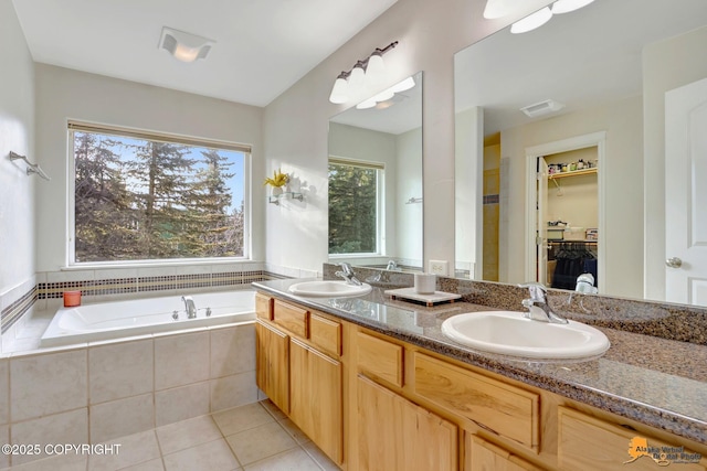 full bath featuring a sink, a bath, tile patterned floors, and a spacious closet