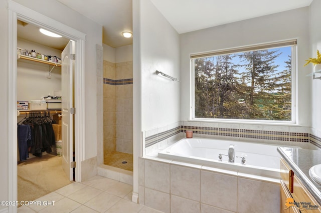 full bath with plenty of natural light, a garden tub, tile patterned floors, and a tile shower
