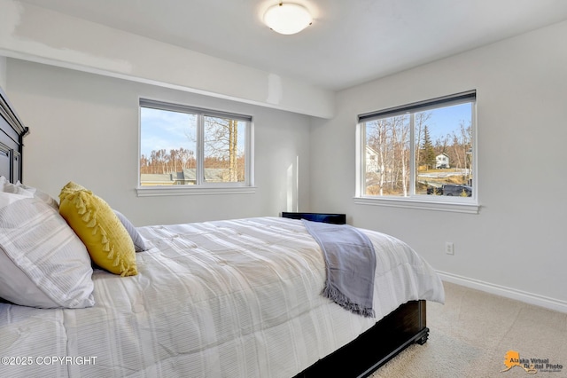 carpeted bedroom featuring baseboards and multiple windows