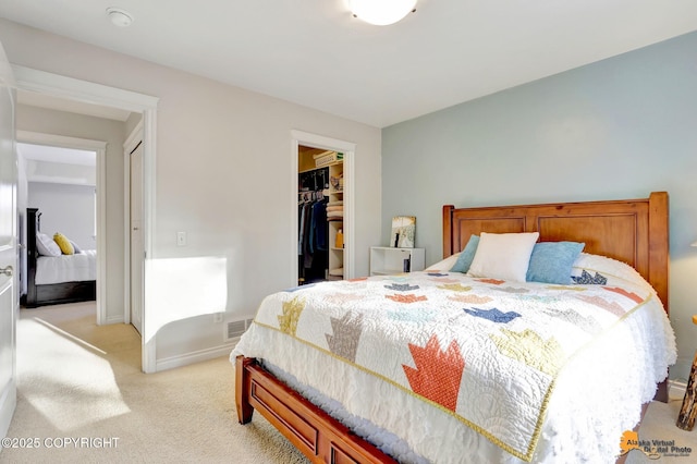 bedroom featuring baseboards, light carpet, a closet, and a spacious closet