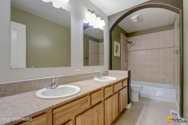 full bathroom featuring double vanity, toilet, a sink, and tile patterned flooring