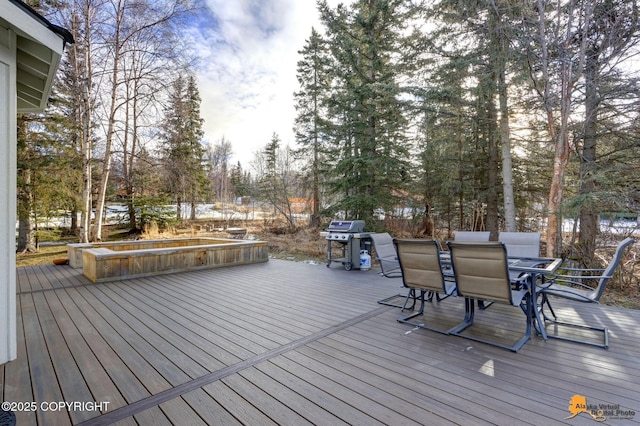 wooden deck with outdoor dining space and grilling area