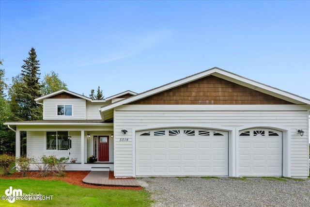 view of front of home featuring an attached garage and gravel driveway